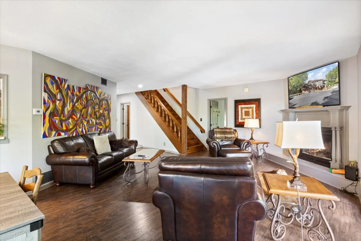 A stylish, comfortable living area featuring plush seating, vibrant abstract artwork, and a contemporary fireplace. The arrangement encourages conversation and relaxation, embodying the spirit of shared time together.