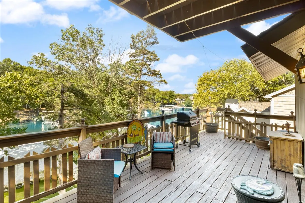A well-appointed deck overlooking the water, featuring comfortable seating and a grill. The vantage point offers sunset views and an inviting space for gatherings after a day on the lake.